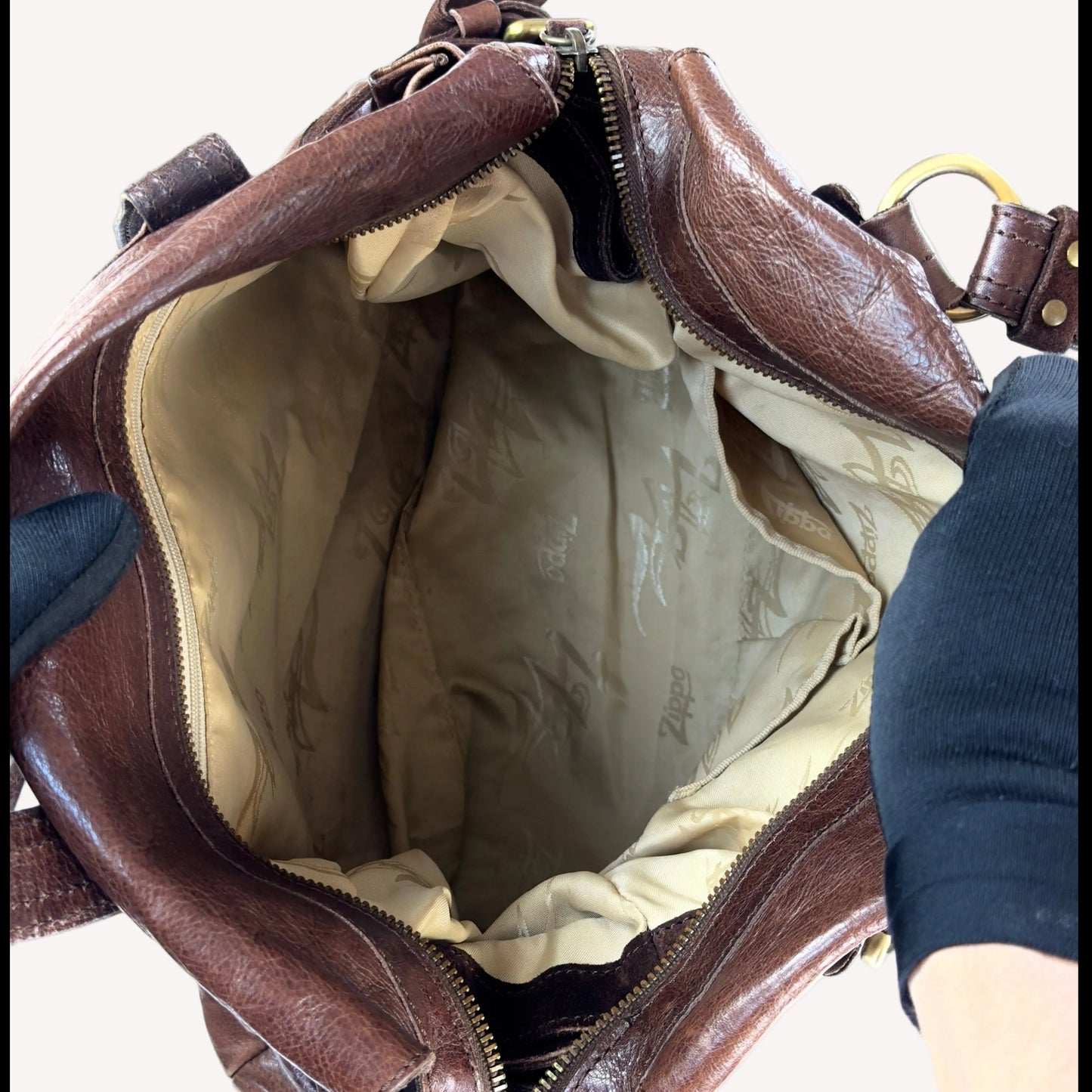 Vintage Zippo slouchy shoulder bag crafted from distressed brown crinkled leather, featuring a sturdy suede base and utilitarian antique brass hardware.