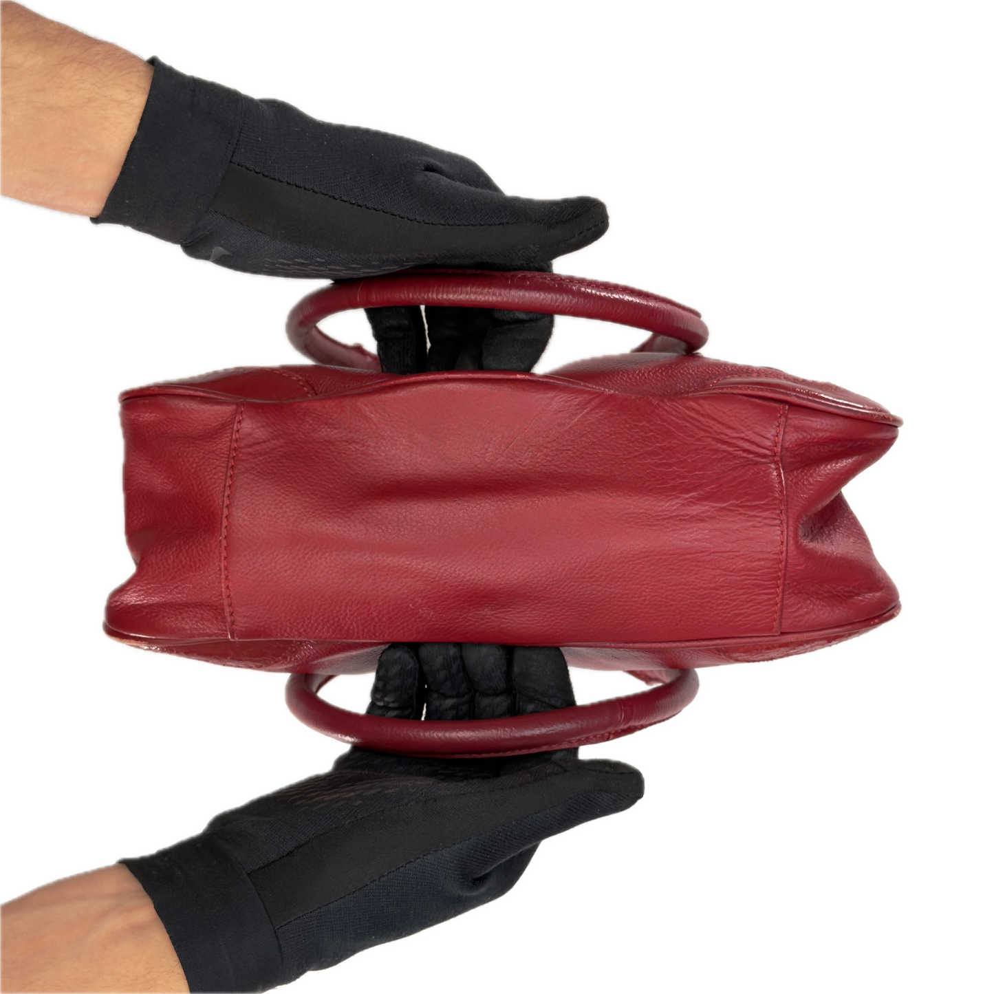 Bottom of an elongated vintage Y2K Collection by Debenhams red genuine leather shoulder bag with silver hardware.