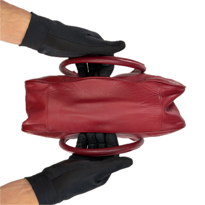 Bottom of an elongated vintage Y2K Collection by Debenhams red genuine leather shoulder bag with silver hardware.