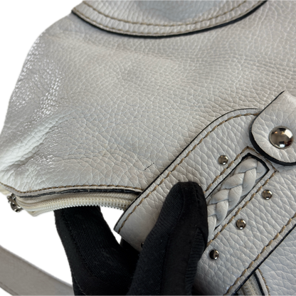 Vintage Coccinelle white pebbled leather hobo bag featuring braided leather details and silver stud hardware.