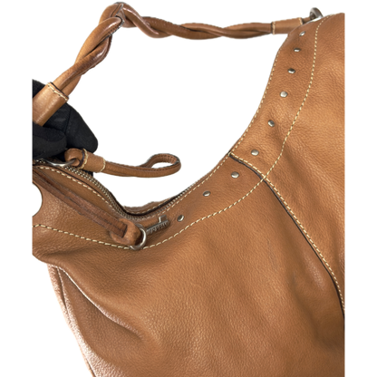 Vintage Fossil tan brown leather hobo bag featuring a braided shoulder strap, silver studs, and a signature key charm.