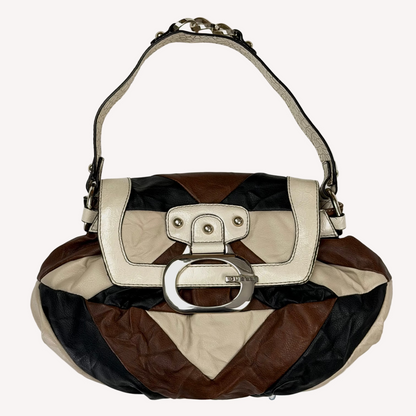 Vintage Guess slouchy hobo bag featuring a black, brown, and cream geometric pattern with a large silver G buckle closure.