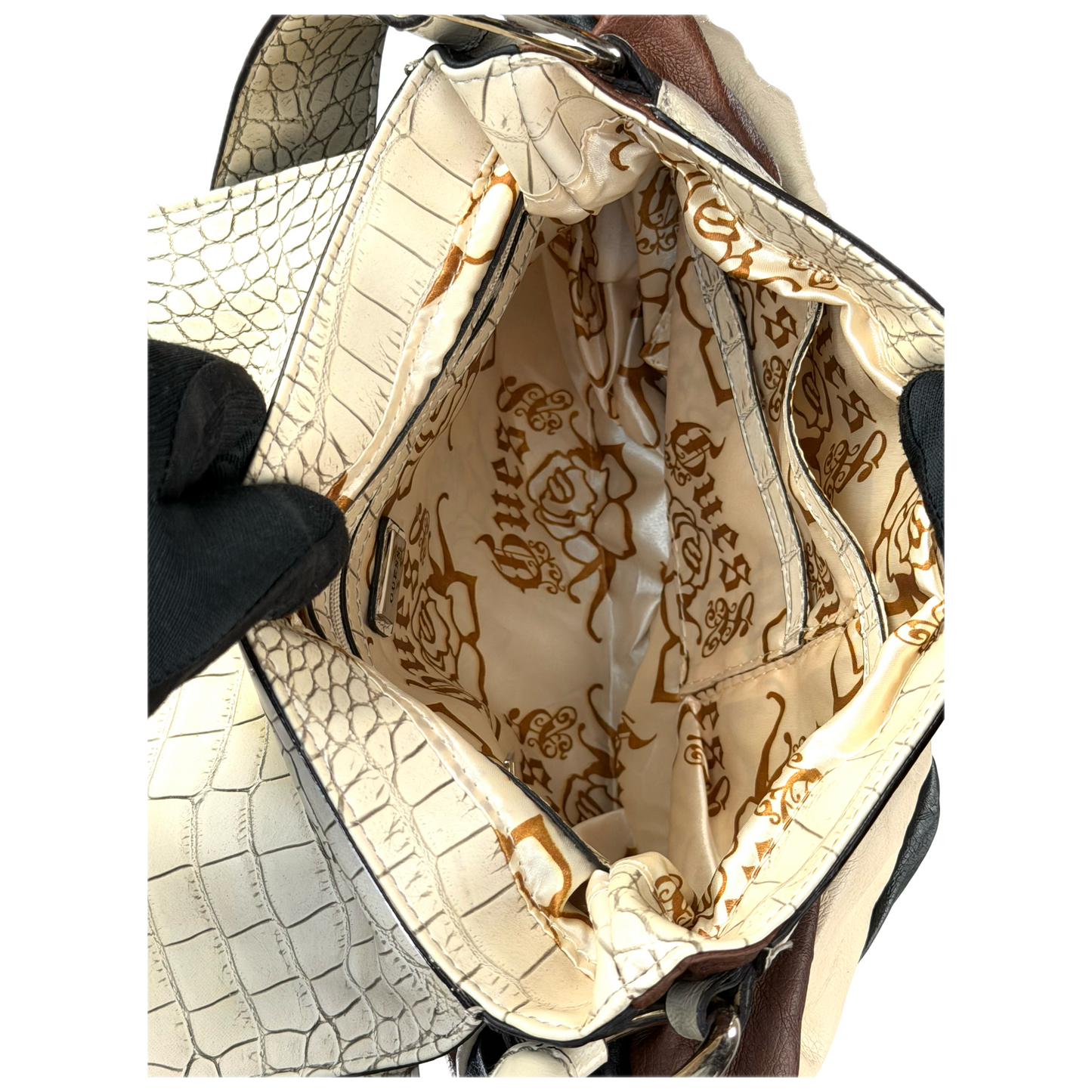 Vintage Guess slouchy hobo bag featuring a black, brown, and cream geometric pattern with a large silver G buckle closure.