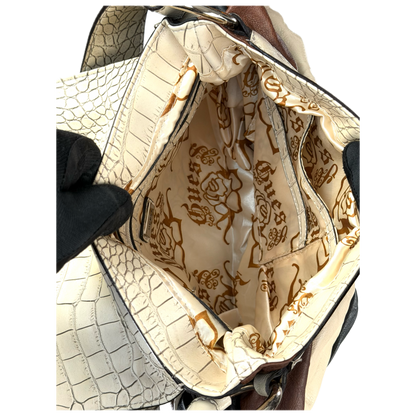 Vintage Guess slouchy hobo bag featuring a black, brown, and cream geometric pattern with a large silver G buckle closure.