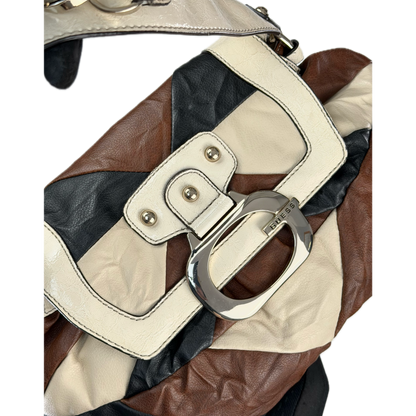 Vintage Guess slouchy hobo bag featuring a black, brown, and cream geometric pattern with a large silver G buckle closure.