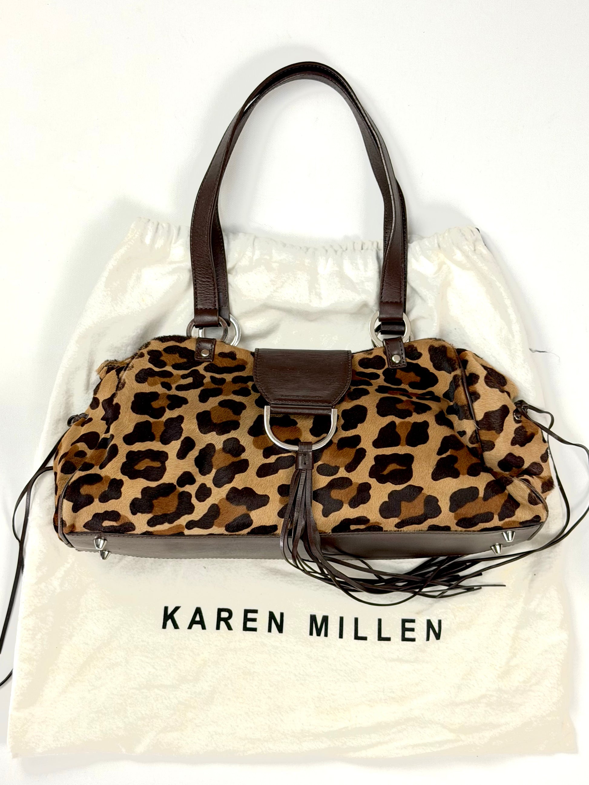Vintage Karen Millen leopard print pony hair East-West shoulder bag featuring brown leather straps, silver hardware, and a leather fringe tassel.