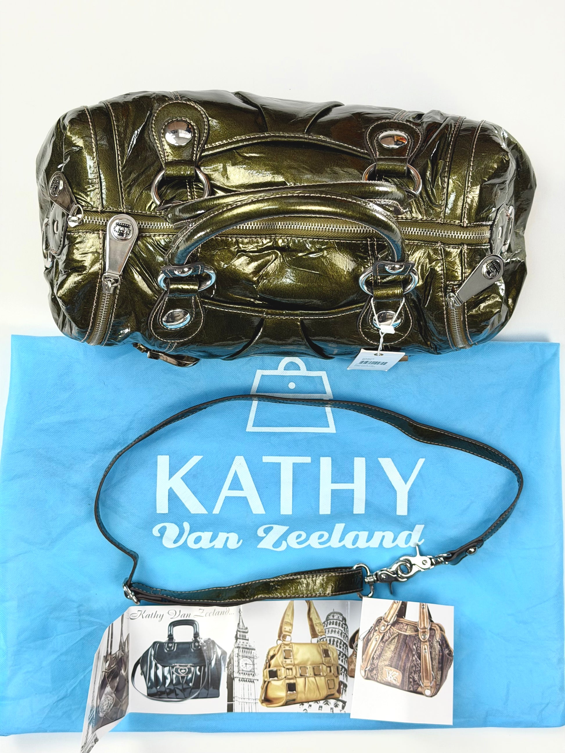 Metallic handbag on a blue surface with 'Kathy Van Zeeland' branding.