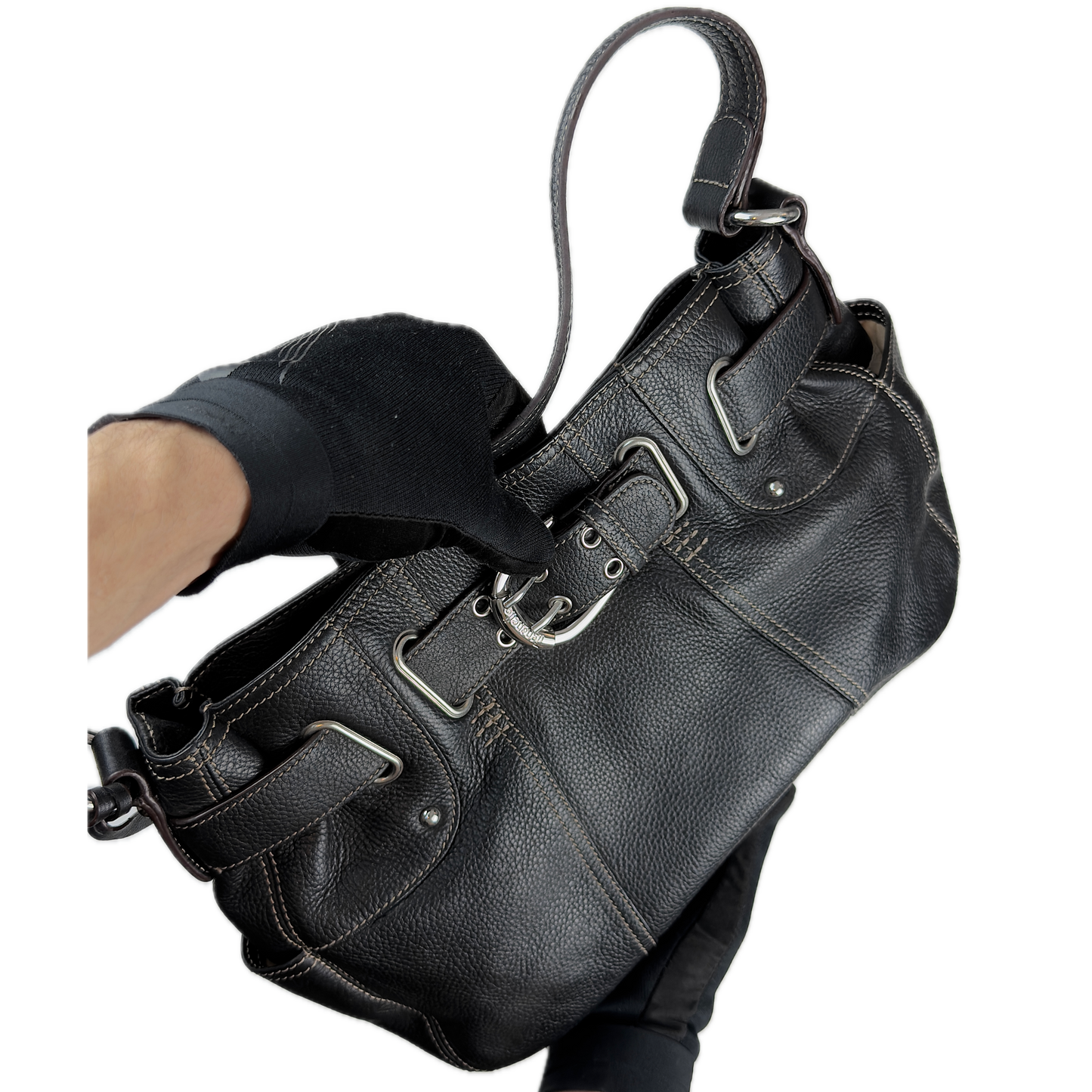 Vintage Tignanello black pebbled leather shoulder bag featuring a silver front buckle, contrast stitching, and side pockets.