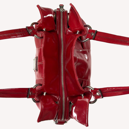 Vintage Y2K Tignanello cherry red pebbled leather shoulder bag featuring glossy patent trim, white contrast stitching, and a silver logo plaque.