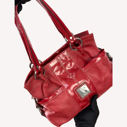 Vintage Y2K Tignanello cherry red pebbled leather shoulder bag featuring glossy patent trim, white contrast stitching, and a silver logo plaque.