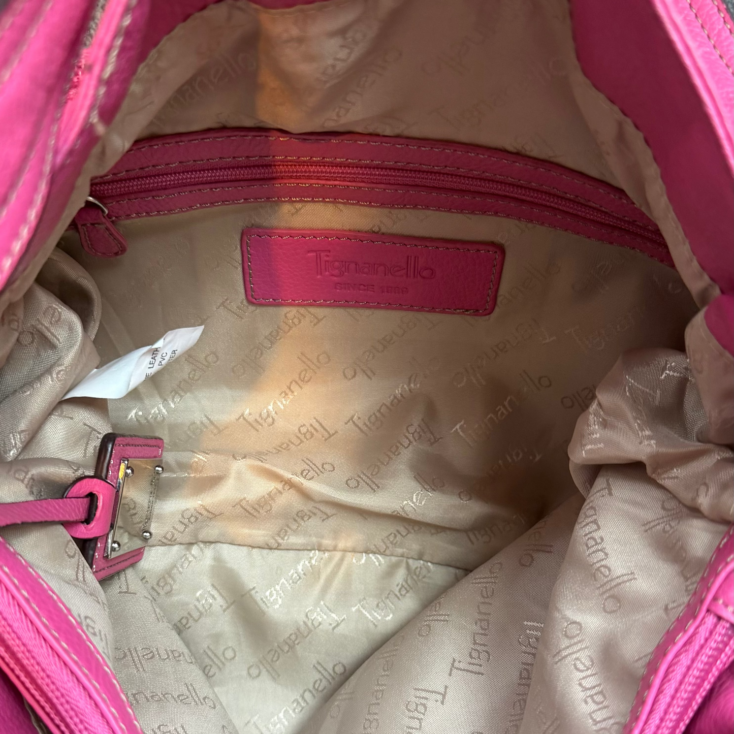 Vintage Y2K Tignanello hot pink pebbled leather shoulder bag featuring a statement silver front buckle, side slip pockets, and a branded metal hanging tag.