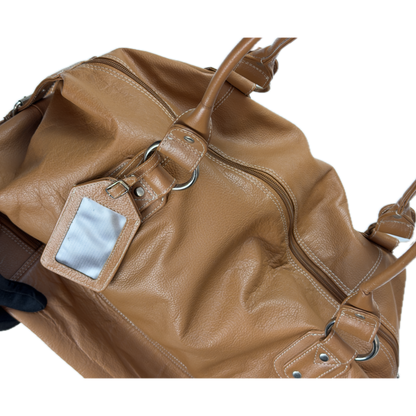 Vintage Tommy & Kate tan brown leather weekender travel bag featuring white contrast stitching, a lower shoe compartment, and a luggage tag.