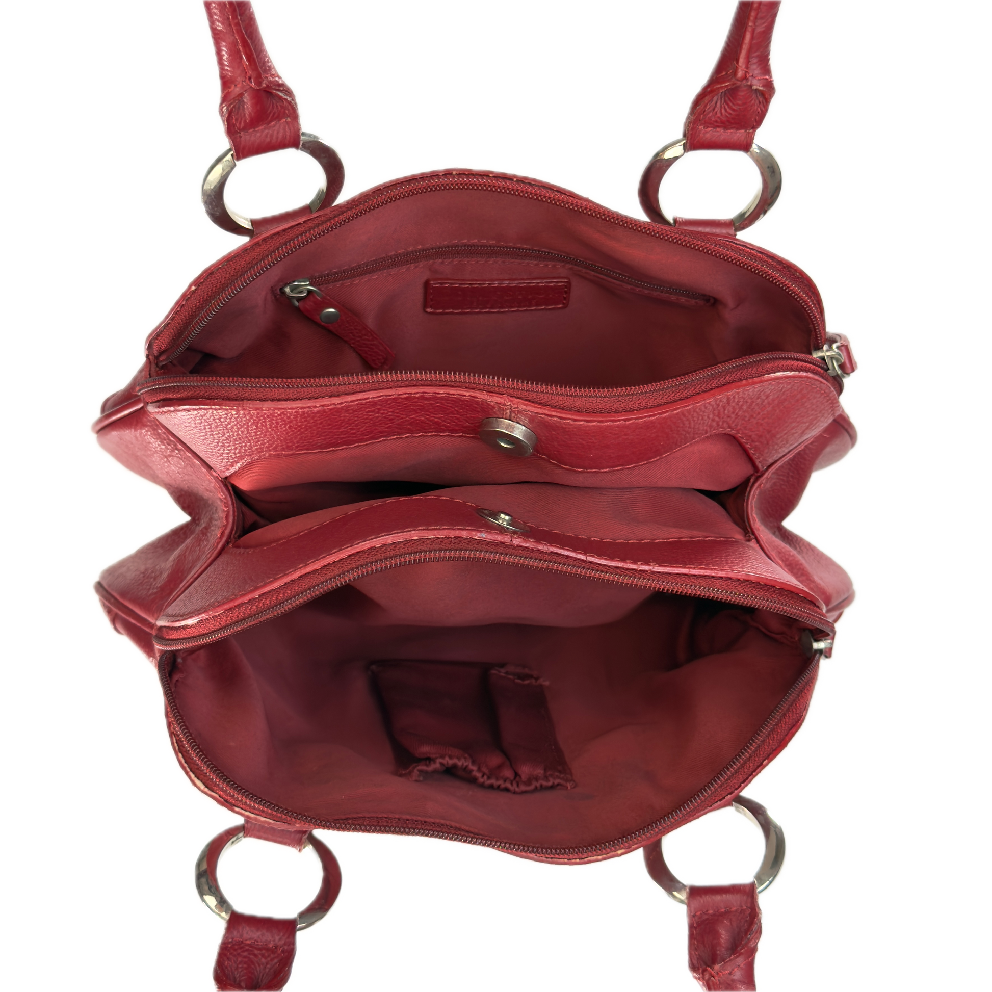 An open red leather handbag shown from above, revealing multiple interior compartments, zippered pockets, and silver-tone metal hardware including D-rings and a snap closure.