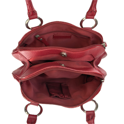 An open red leather handbag shown from above, revealing multiple interior compartments, zippered pockets, and silver-tone metal hardware including D-rings and a snap closure.