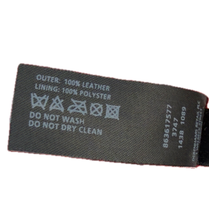 A close-up of a black fabric product label with white printed text and care symbols, including 'OUTER: 100% LEATHER', 'LINING: 100% POLYESTER', and 'DO NOT WASH DO NOT DRY CLEAN'.