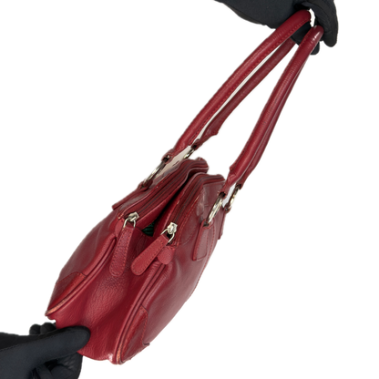 Side view of an elongated vintage Y2K Collection by Debenhams red genuine leather shoulder bag with silver hardware.