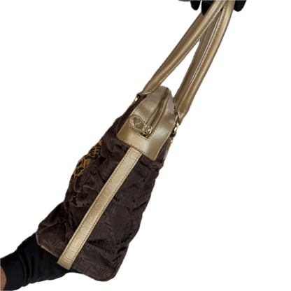 Side view of a vintage Y2K Liz Claiborne brown zebra animal print tote bag featuring tonal brown faux leather handles against a black background.