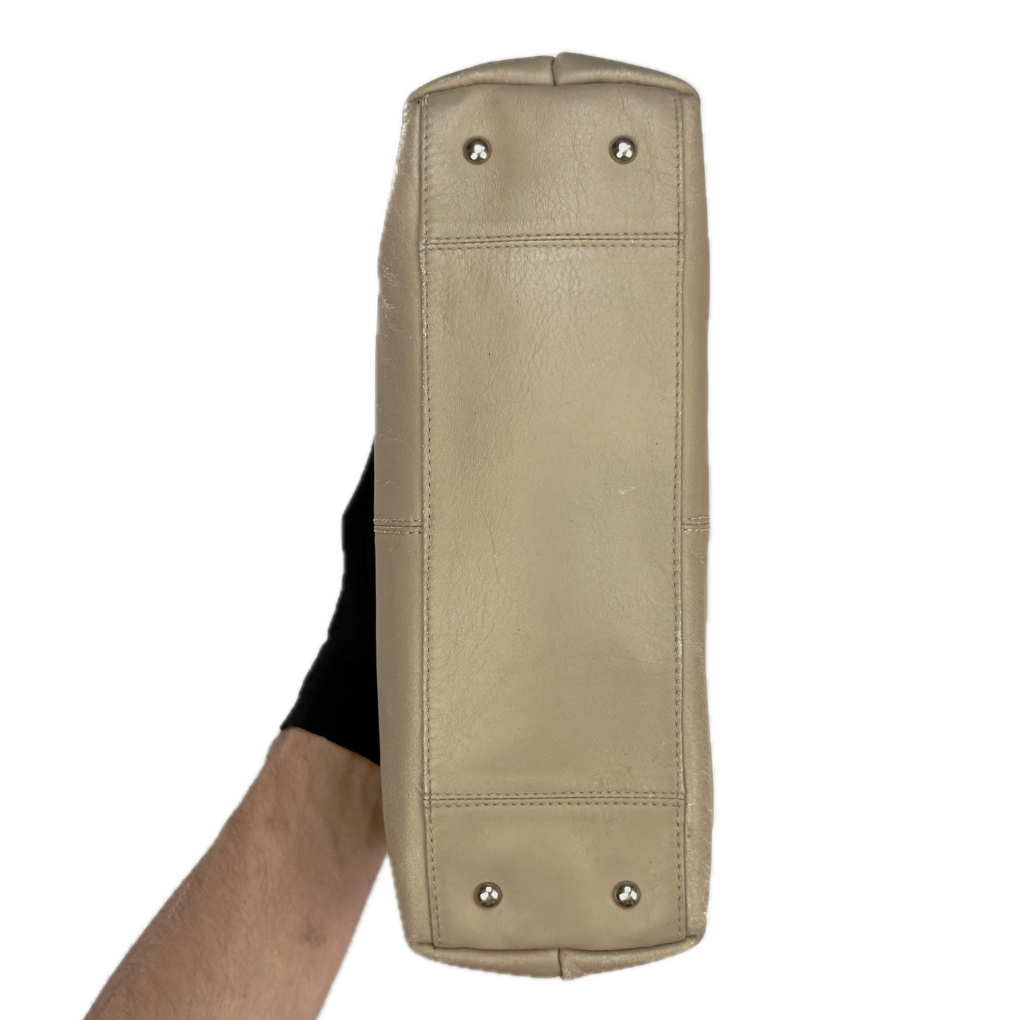 Bottom of a structured vintage Y2K Tula cool beige genuine leather top handle bag with silver hardware.
