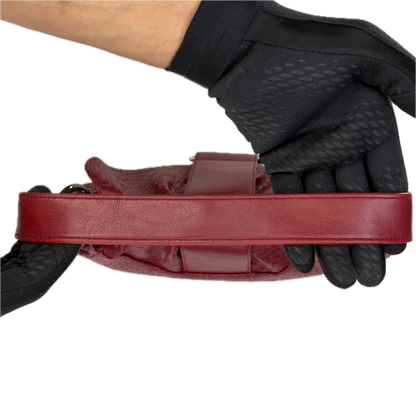 Top down view of a vintage Y2K Wallis red woven faux leather baguette shoulder bag featuring gunmetal hardware and a smooth center flap.