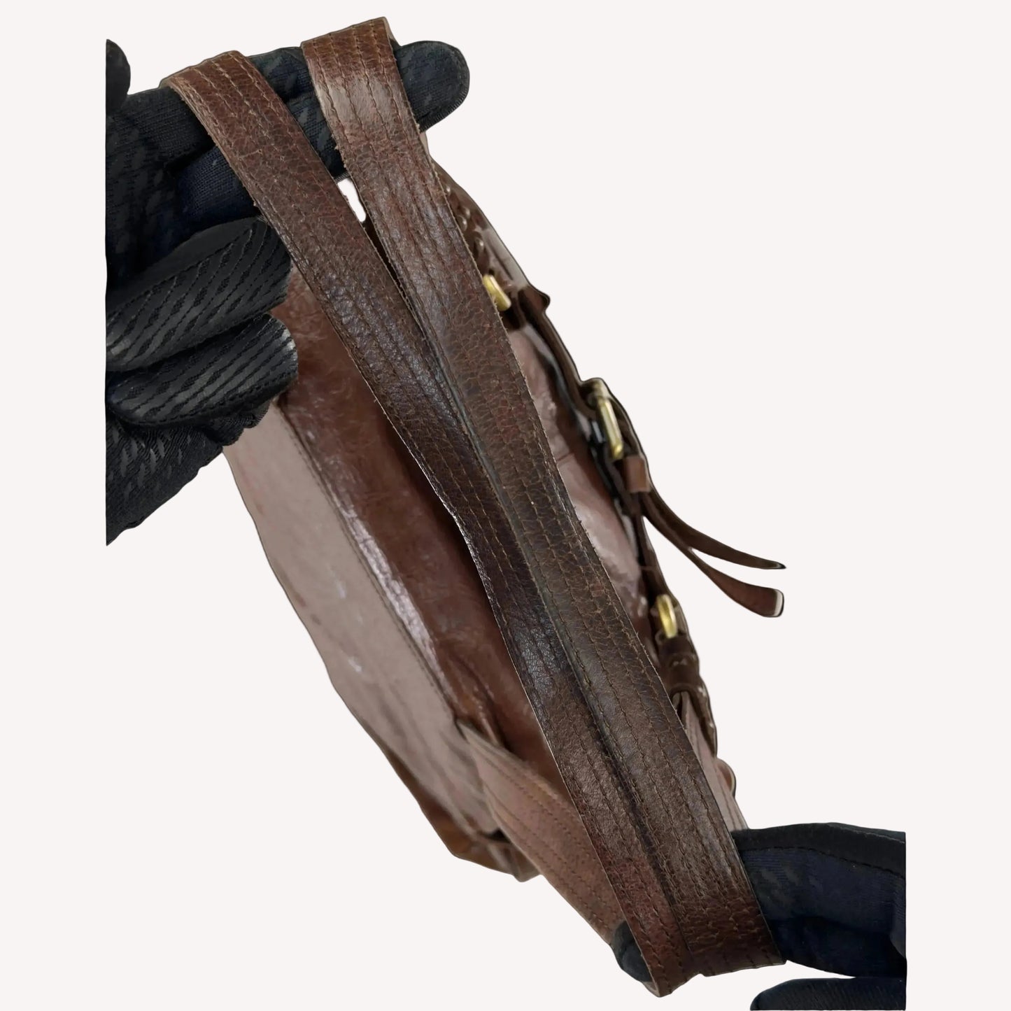 Close-up of the antique brass utilitarian hardware and distressed brown leather on a rare vintage Zippo archive bag.